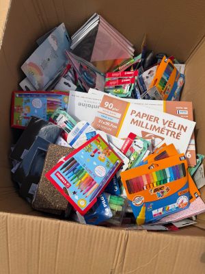 une boîte en carton remplie de livres et d'autres fournitures scolaires