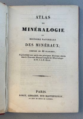 un livre ouvert posé sur une table à côté d'une tasse de café