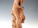 l'image d'une statue de femme assise sur un rocher