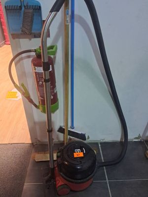 a vacuum and a broom on the floor next to a wall
