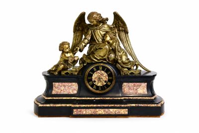 une statue représentant un ange tenant un enfant sur une horloge