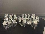 six figurines en cristal posées sur une table noire, sur fond blanc