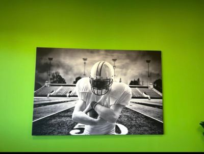 une photo en noir et blanc d'un footballeur devant un mur vert