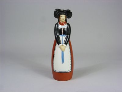 une figurine représentant une femme vêtue d'une robe et tenant une canne