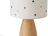 une photo d'une lampe de table avec un pied en bois orné de pois colorés