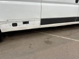 a white van with a black stripe parked in a parking lot