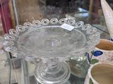 une vitrine en verre sur laquelle sont posés un plat à gâteau et une paire de chaussures