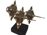 three gold starfishs on a black stand on a white background