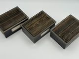 trois petites boîtes en bois avec des couvercles en bois, posées sur une surface blanche