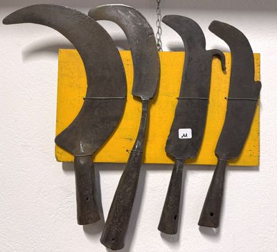 cinq couteaux accrochés à une planche jaune sur le mur