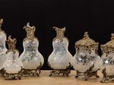 six silver and glass vases sitting on top of a wooden table