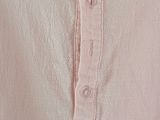 the shirt is pink and has a ruffled neckline