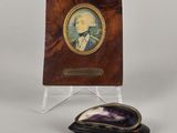 une image représentant la photo d'un homme en costume à côté d'une plaque en bois