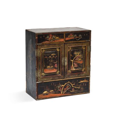 une armoire peinte en noir et or, dotée de deux portes et de tiroirs