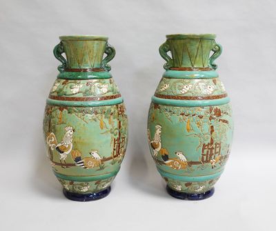 deux vases verts posés l'un à côté de l'autre sur une surface blanche