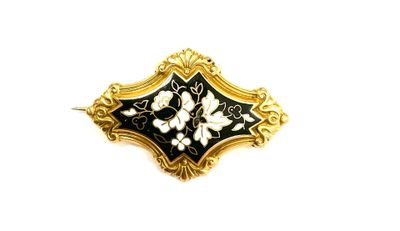 an image of a black and gold brooch with white flowers on it