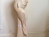 a statue of a bird that is sitting on a wooden stand