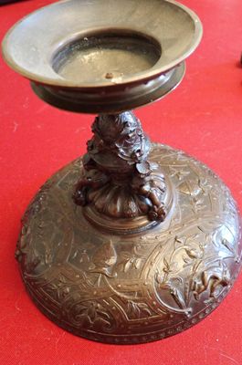 une plaque en bronze sur laquelle est posée une statue, posée sur une table rouge