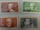 quatre timbres différents, de couleurs et de tailles variées, sur un fond blanc