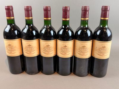 six bottles of wine are lined up in a row on a table