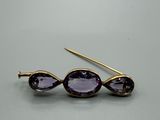 un gros plan sur une paire de boucles d'oreilles ornées de pierres violettes