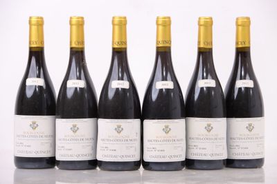 six bouteilles de vin sont alignées sur une table