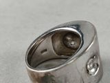 a close up of a silver ring with a diamond on it