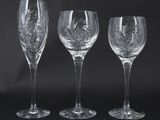 three wine glasses with etched designs on them against a black background
