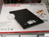 une balance électronique noire exposée dans un magasin