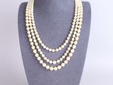 un collier de perles à trois rangs présenté sur un mannequin