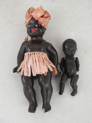 deux poupées noires assises l'une à côté de l'autre