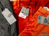 three men ' s pants with price tags on them sitting next to each other