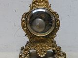 une horloge en or posée sur une table, à côté d'une clé