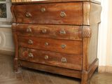 une commode en bois sur laquelle est posé un vase