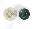 a white bowl and a green bowl on a white table