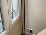 un lampadaire noir près d'une fenêtre dans une chambre à coucher