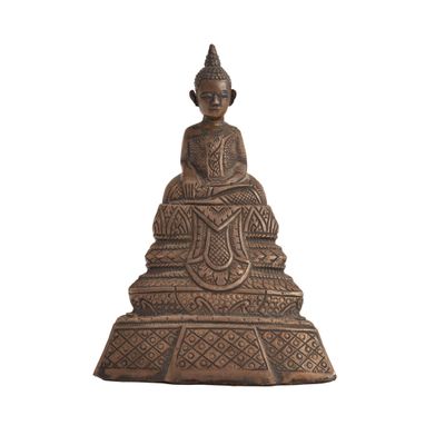 une statue en bronze représentant un Bouddha assis au sommet d'un rocher