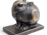a bronze sculpture of a rabbit sitting on a base