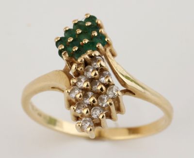 une photo en gros plan d'une bague sertie de diamants et d'une pierre verte