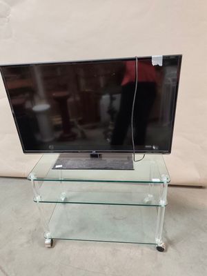 a glass tv stand with a laptop on top of it