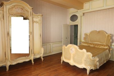 une chambre avec un lit, des commodes et un miroir