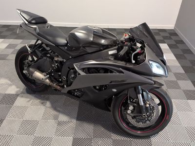 a black motorcycle that is parked on a checkered floor