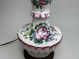 a lamp that is sitting on a table with flowers on it