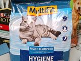 a bag of cat food sitting on a table next to a dog