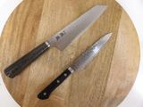 two knives sitting on a cutting board on a table