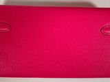 a pink leather wallet with two handles and a clasp