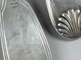 two spoons that are sitting next to each other on a table