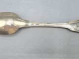 an antique silver spoon with a flower design on the handle