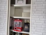 a small christmas tree in the corner of a bookcase
