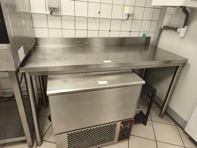 un plan de travail en acier inoxydable dans une cuisine équipée d'un lave-vaisselle